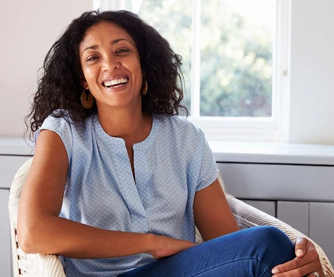 Smiling woman seated in a bright room
